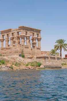 Ancient Philae Temple ruins along the Nile River in Aswan, featuring historic Egyptian architecture.