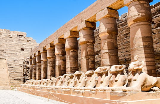 Explore the grandeur of an ancient Egyptian temple with pharaonic columns under a clear blue sky.