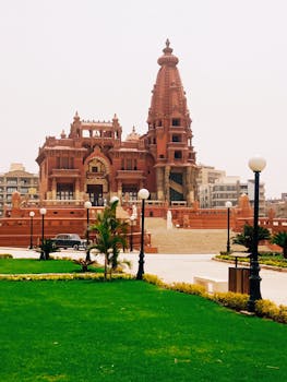 Stunning view of Baron Empain Palace with lush garden in Cairo, Egypt.