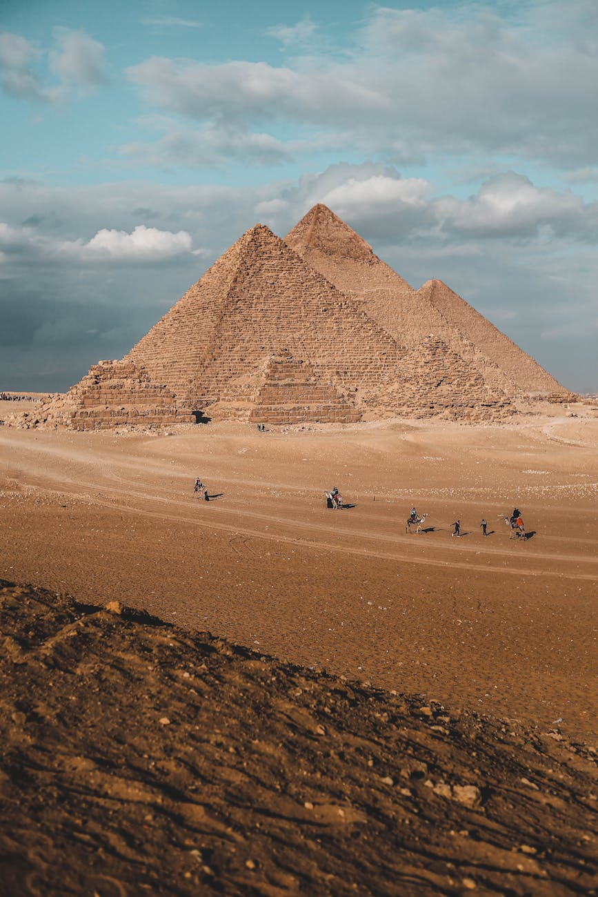 Stunning landscape of the Pyramids of Giza under a blue sky, capturing Egypt's ancient wonder.