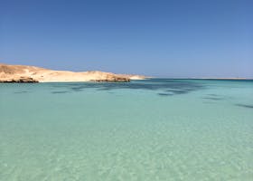 Crystal clear waters and sandy shores of the Red Sea under a clear blue sky in Egypt.