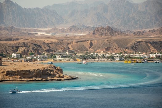 Aerial view of Sharm El Sheikh coastline with turquoise sea and mountainous backdrop.