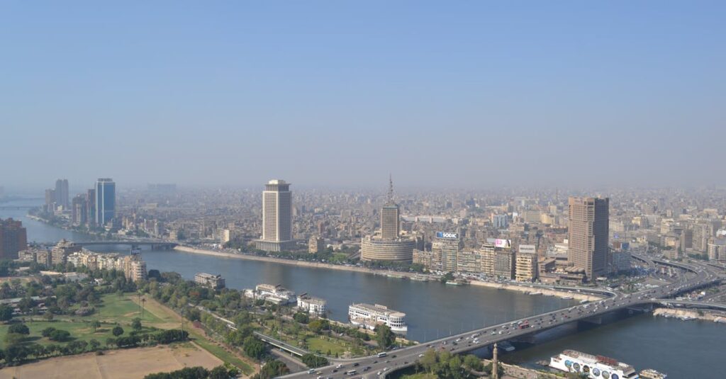 Aerial view of downtown Cairo with Nile River and urban skyline showcasing landmarks and busy traffic.