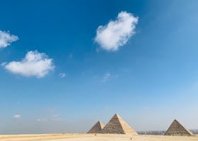 The historic Pyramids of Giza framed by a vast desert and blue sky, perfect for travel and tourism themes.